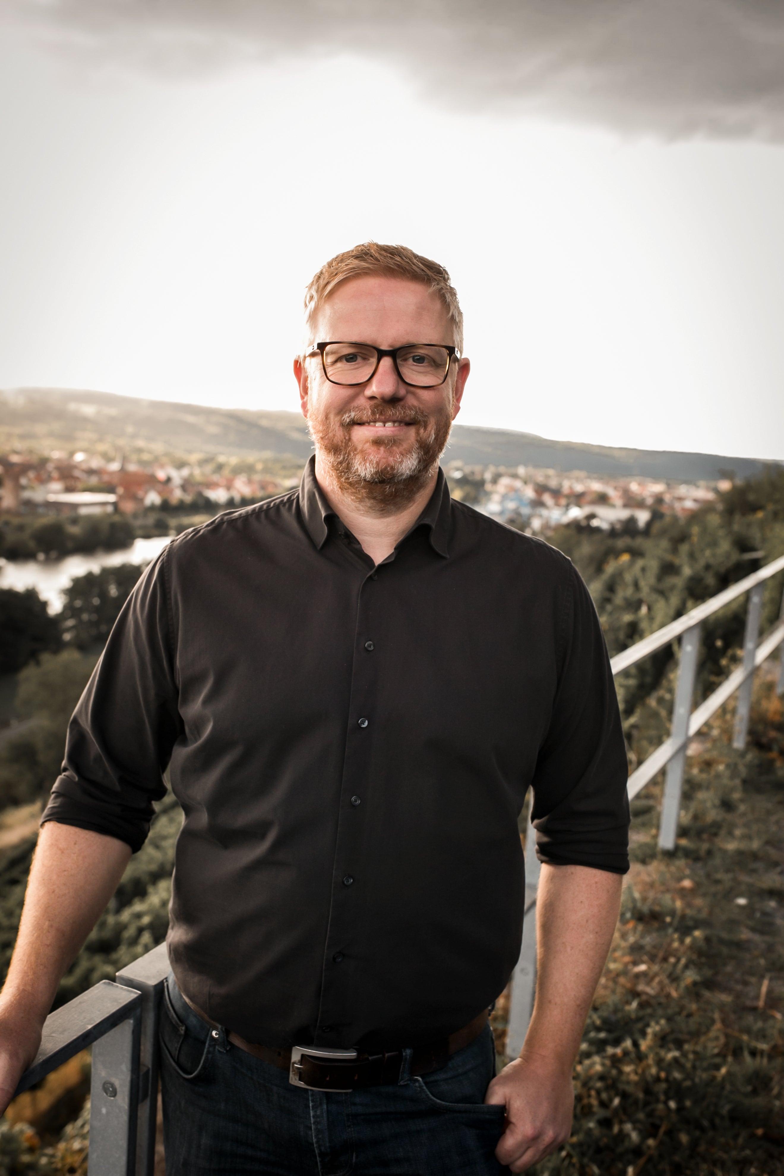 Portrait des Winzers vom Weingut A. Waigand vor einer Weinberglandschaft